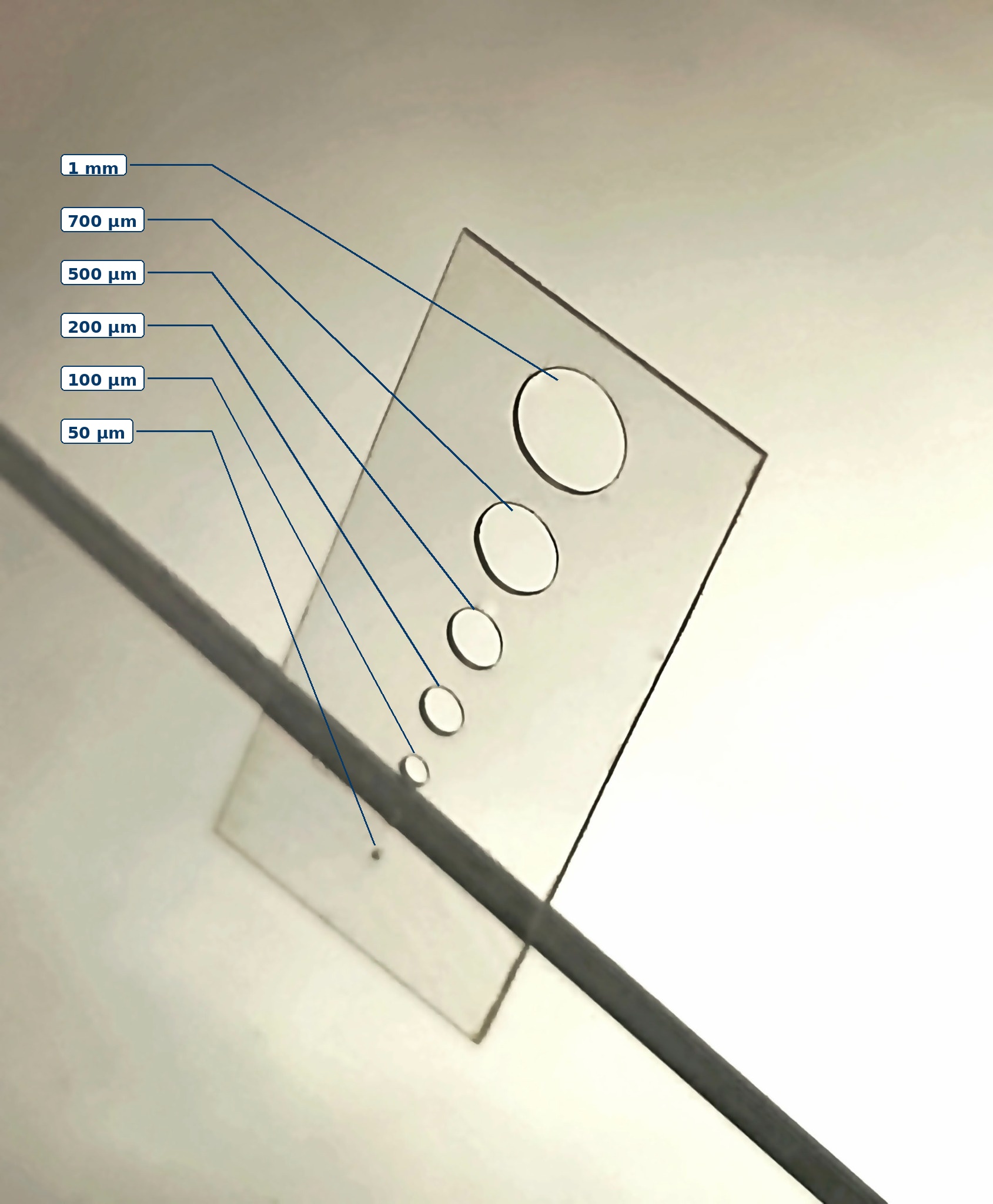 125 micrometer fused silica plate with laser-drilled holes from 1 millimeter to 50 micrometers