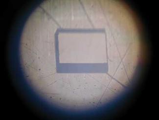FIGURE 1. A rectangular 1 × 1 mm2 hole cut in 400 µm plastic sheet (nylon) by 266 nm, 4 ps pulses exhibits no obvious traces of residual carbon that typically develops as black areas covering the cut. Note that adding 1064 nm picosecond pulses causes carbon to appear and the quality of the cut deteriorates. Such peculiarities arise from the undesirable heating of the plastic by the 1064 nm pulses.